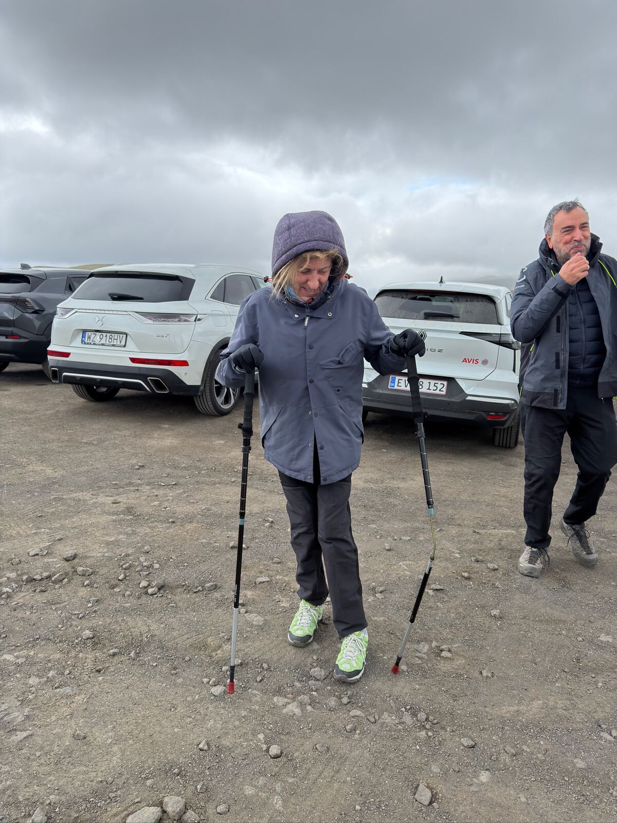Mujer caminando con bastones de trekking por terreno pedregoso